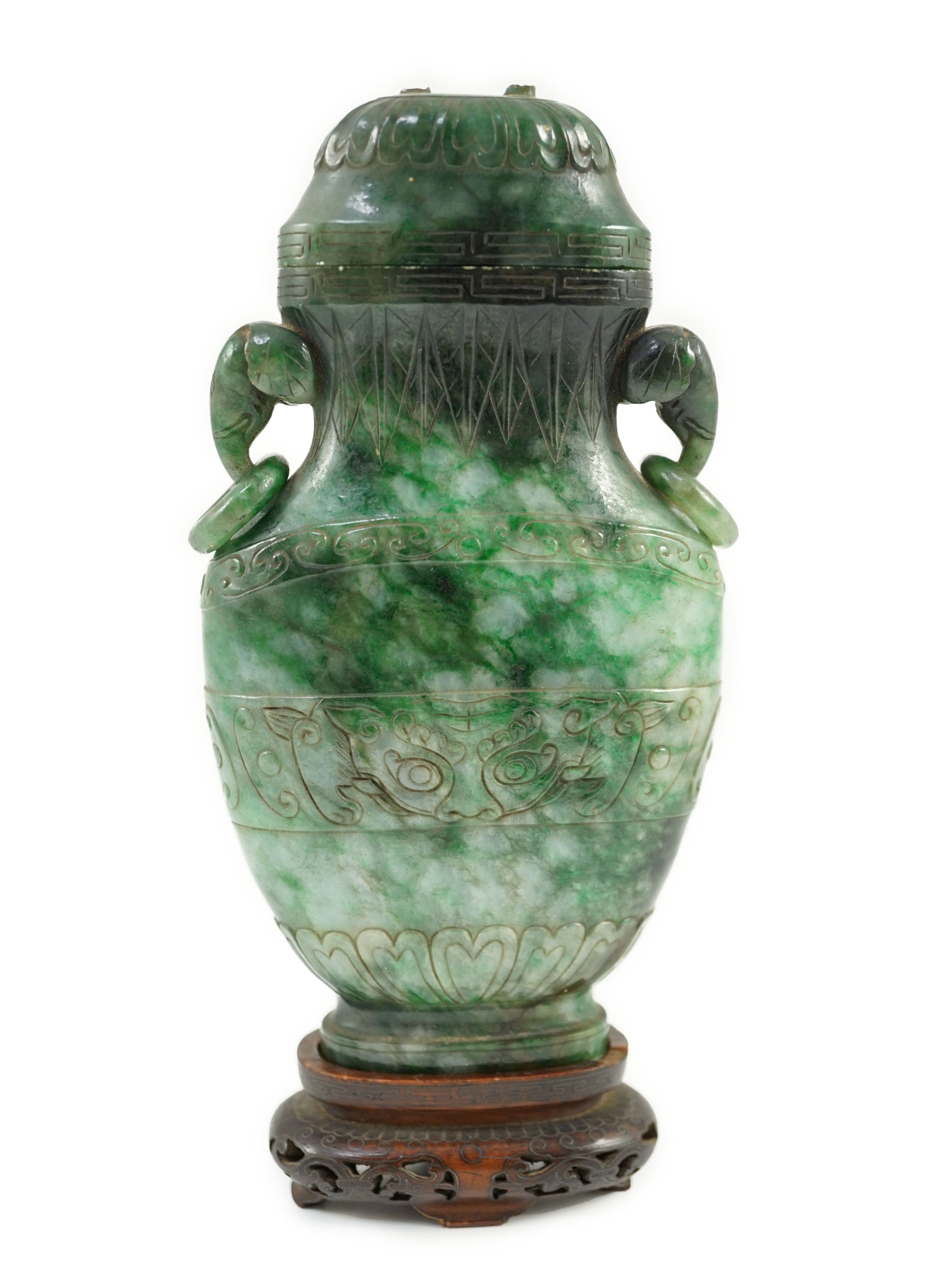 A Chinese archaistic green jadeite vase and cover, late Qing dynasty, 14.5 cm high, Silver wire inlaid wood stand, cover finial missing